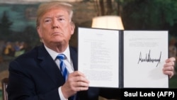 U.S. -- U.S. President Donald Trump signs a document reinstating sanctions against Iran after announcing the US withdrawal from the Iran Nuclear deal, in the Diplomatic Reception Room at the White House in Washington, May 8, 2018