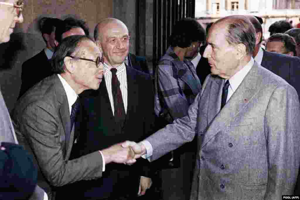 FRANCE - (FILES) In this file photo taken on March 29, 1989 French President François Mitterrand (R) shakes hands with Chinese American architect Ieoh Ming Pei, as Louvre Museum director Michel Laclotte looks on, during the public opening of the Louvre Py