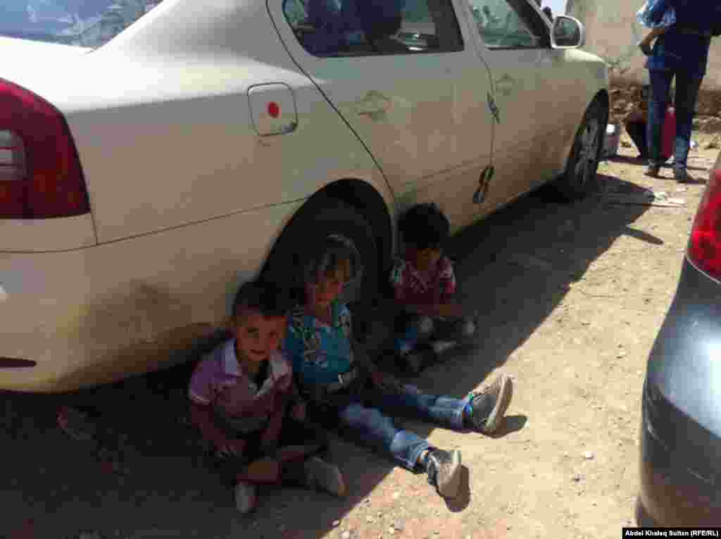 Children seek shelter from the sun.