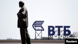 A sign for VTB Bank atop a building is seen beyond a monument of Soviet state founder Vladimir Lenin in central Stavropol, in southern Russia.