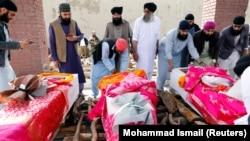 Men prepare coffins for the victims of an attack on a Sikh religious complex in Kabul on March 26.