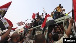 Supporters of the Muslim Brotherhood's presidential candidate, Muhammad Morsi, celebrate on top of a bus at Tahrir Square in Cairo on June 18.