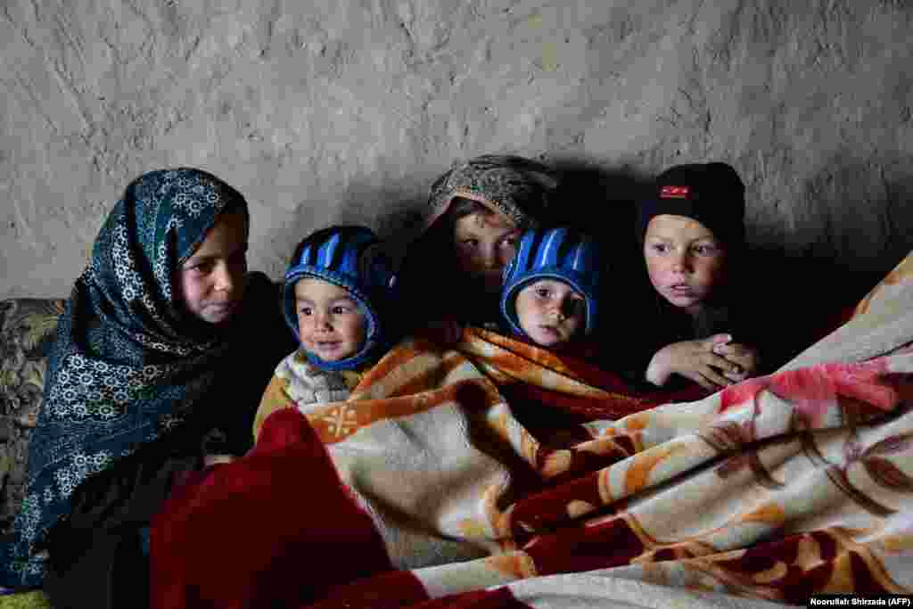 Children warm themselves in a mud house at a refugee camp&nbsp;in Laghman, eastern Afghanistan. Half a million Afghans have been displaced by war, and many refugees have been returned to the country from Pakistan, Europe, and Iran. January 11, 2017. (AFP/Noorullah Shirzada) &nbsp;