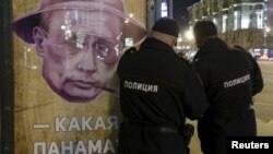 Полиция у постера с Владимиром Путиным "Какая Панама?" на остановке в Москве