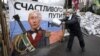 UKRAINE – A pro-European integration supporter washes a banner with an image of Russian President Vladimir Putin near a barricade in Independence Square where the supporters are holding a rally, in Kyiv January 9, 2014