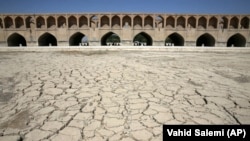 In this July 10, 2018 photo, the Zayandeh Rood river no longer runs under the 400-year-old Si-o-seh Pol bridge, named for its 33 arches, in Isfahan, Iran.