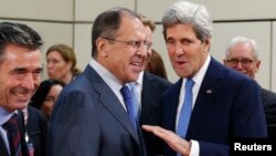 Secretarul de stat american John Kerry (dreapta) și omologul său rus Serghei Lavrov la sediul NATO din Bruxelles, 4 decembrie.