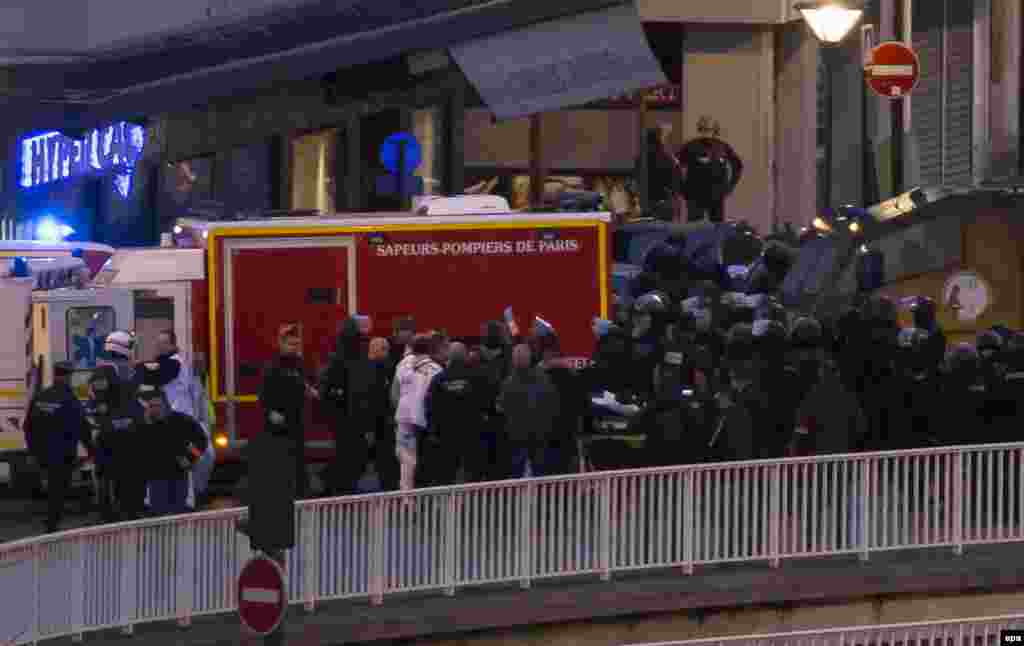Služba hitne pomoći u evakuaciji pripadnika elitne policijske jedinice (BRI) ranjenog u napadu na HyperCasher supermarket u Porte de Vincennes u istočnom Parizu nakon što je napadač otvorio vatru i uzeo taoce.