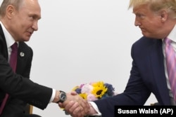 Дональд Трамп и Владимир Путин обмениваются рукопожатием в Осаке. 28 июня2019 года