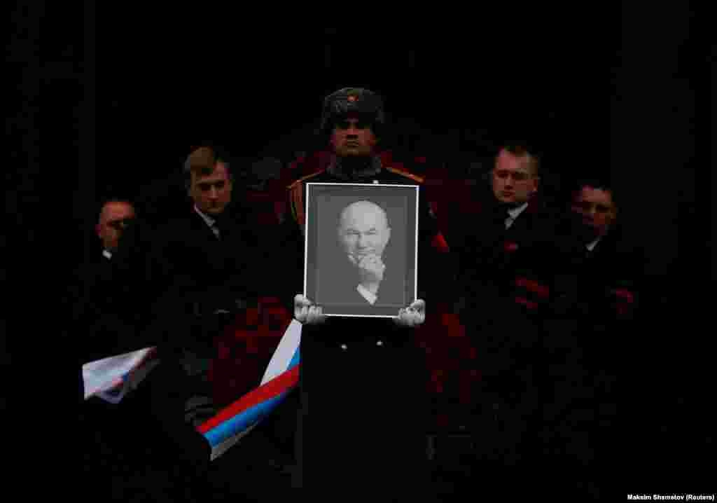 Pallbearers carry the coffin and a portrait of the former mayor of Moscow, Yury Luzhkov, after a memorial service in Moscow on December 12. (Reuters/Maxim Shemetov)