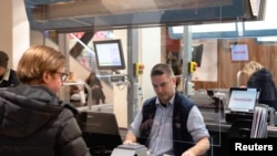 Sweden - A cashier works behind a plexiglass screen at a grocery store, as the spread of the coronavirus disease (COVID-19) continues, in Stockholm