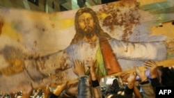 Christians hold a blood-stained portrait of Jesus Christ during a protest in Alexandria on January 2.