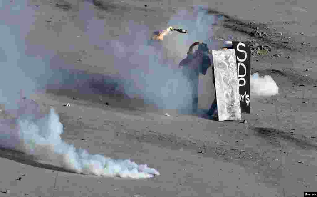 A protester throws a petrol bomb as riot police fire water cannons and tear gas during a protest on Taksim Square in Istanbul. (Reuters/Osman Orsal)