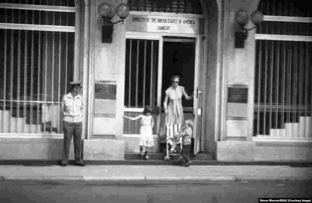 A woman pushing through the door of the U.S. Embassy in East Berlin. 