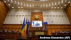Президент України Володимир Зеленський (на екрані) під час звернення через відеозв'язок до парламенту Румунії. Бхарест, 4 квітня 2022 року