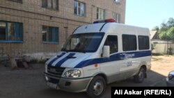 Ақтөбедегі отбасылық жатақхана алдында тұрған полиция көлігі (Көрнекі сурет). 