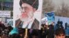 Afghans protesting allegations of Iranian abuse of Afghan refugees hold an image of Iranian Supreme Leader Ali Khamenei at a Kabul demonstration on January 13.