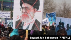 Afghans protesting allegations of Iranian abuse of Afghan refugees hold an image of Iranian Supreme Leader Ali Khamenei at a Kabul demonstration on January 13.