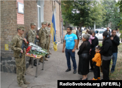 Військові та родина Ігіта Гаспаряна біля будинку з меморіальною дошкою на його честь