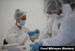 Health workers are seen at a mobile-testing station for the coronavirus in Almaty.