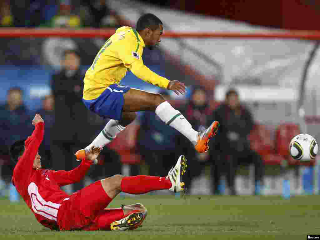 South Africa -- Brazil's Robinho (top) jumps over North Korea's Ri Jun-il during a 2010 World Cup Group G soccer match at Ellis Park stadium in Johannesburg,15Jun2010 - Brazil's Robinho (top) jumps over North Korea's Ri Jun-il during their 2010 World Cup Group G soccer match at Ellis Park stadium in Johannesburg June 15, 2010. REUTERS/Kai Pfaffenbach (SOUTH AFRICA - Tags: SPORT SOCCER SPORT SOCCER WORLD CUP)