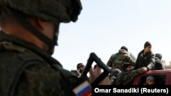 Российский солдат на КПП вблизи Дамаска указывает сирийским войскам направление движения, 2 марта 2018 года.