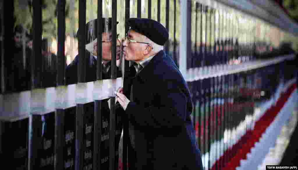 A man kisses a tombstone at the Alley of Martyrs, a cemetery and memorial dedicated to those killed by Soviet troops during the 1990 Black January crackdown, in Baku. Azerbaijan marked the 29th anniversary of the Black January crackdown of the Azerbaijani independence movement in Baku by the Soviet Army in 1990. (AFP/Tofik Babayev)