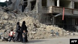 Жінки йдуть повз зруйновану лікарню в сирійському місті Алеппо, 21 квітня 2013 року