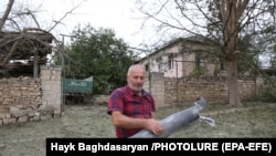 NAGORNO KARABAKH -- A local man carries part of a shell in the city of Martuni, 28 September 2020.