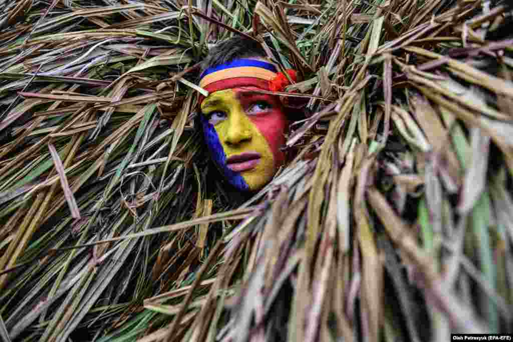 A local man wearing a bear costume made of hay and reeds takes part in celebrations marking the 'Malanka' winter holiday in the village of Krasnoilsk in western Ukraine. (epa-EFE/Oleg Petrasyuk)