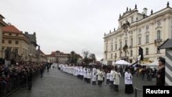 Catholic priests walk in line to attend the funeral ceremony at St. Vitus Cathedral.