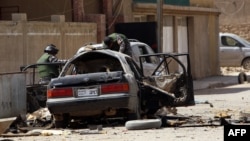 Сили безпеки оглядають один зі знищених вибухом автомобілів у Багдаді