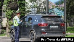 Полицейский останавливает автомобиль в закрытом на карантин Алматы. 25 апреля 2020 года.