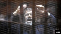 Мохаммед Мурси в клетке в суде незадолго до смерти