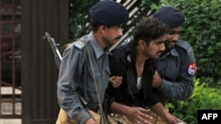 Pakistani police officers help an injured colleague after a suicide attack in Islamabad