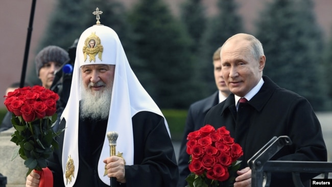 Russian President Vladimir Putin and Patriarch Kirill lay flowers at the monument on the Red Square near the Kremlin, marking National Unity Day in Moscow on November 4, 2018.