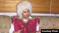 Murad Rakhimov, dressed in traditional Turkmen attire, playing the dutar