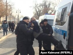 Полиция үкіметке қарсы шеруге келген адамды көлікке күштеп салып жатыр. Алматы, 22 ақпан 2020 жыл.