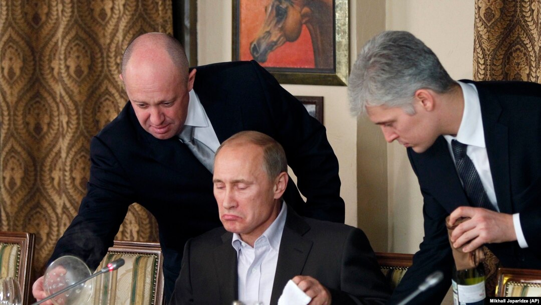 Vladimir Putin este servit de Serghei Prigojin (stânga)