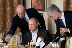 "Некоторые любят погорячее". Владимир Путин на ужине в подмосковном ресторане, принадлежащем бизнесмену Евгению Пригожину (слева), которого связывают с деятельностью "фабрики троллей" и частных военных компаний