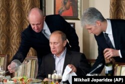 "Некоторые любят погорячее". Владимир Путин на ужине в подмосковном ресторане, принадлежащем бизнесмену Евгению Пригожину (слева), которого связывают с деятельностью "фабрики троллей" и частных военных компаний