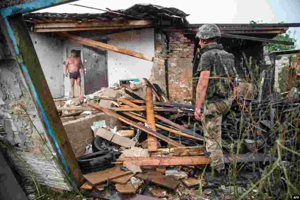 Український вояк оглядає зруйнований після обстрілу будинок в місті Золоте, близько 60 км на захід від Луганська, 16 серпня 2015 року