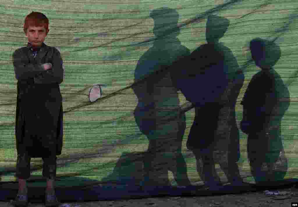 An internally displaced Afghan boy stands outside a temporary shelter at a camp on the outskirts of Kabul. According to UNHCR figures, the number of internally displaced Afghans stood at 683,000 by mid-2014, with estimates of 900,000 by the end of 2015. (epa/Hedayatullah Amid)