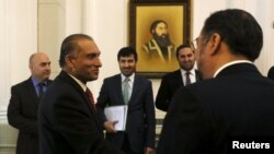 Ahmad Chaudhry, head of Pakistani delegations, (L) talks with Afghan Foreign Minister Salahuddin Rabbani before a meeting in Kabul on February 23.