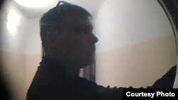 Сотрудник казанского Центра по противодействию экстремизму звонит в дверь одному из активистов 