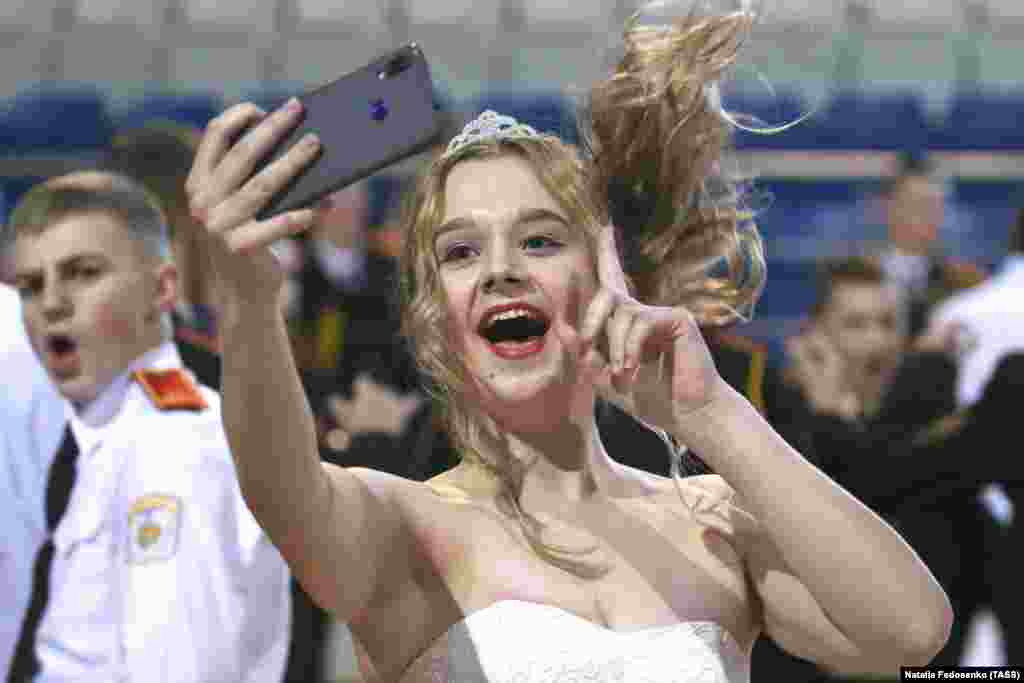 A young girl takes a selfie during a seasonal cadets&#39; ball in Minsk, Belarus. (TASS/Natalia Fedosenko)