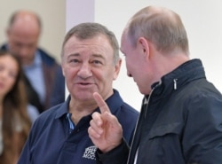 Russian President Vladimir Putin (right) speaks with Arkady Rotenberg as they attend the opening ceremony for a bridge linking Ukraine's Crimean Peninsula to Russia in May 2018.