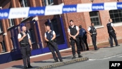 Police stand as they secure the area around a police building in the southern Belgian city of Charleroi following a machete attack on August 6 that left two policewomen wounded.