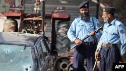 Pakistani policemen stand at the site of the shooting in Islamabad of Brigadier Moin Haider.