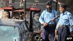 Pakistani policemen stand at the site of the shooting in Islamabad of Brigadier Moin Haider.